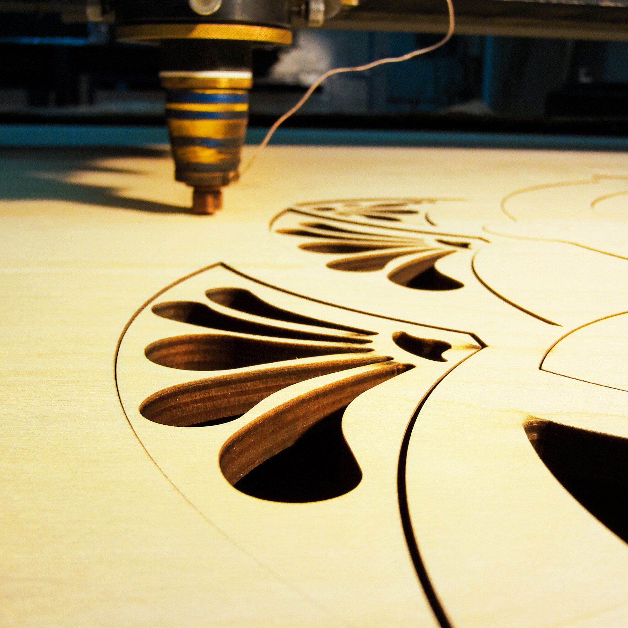 Laser cutting intricate wood design.