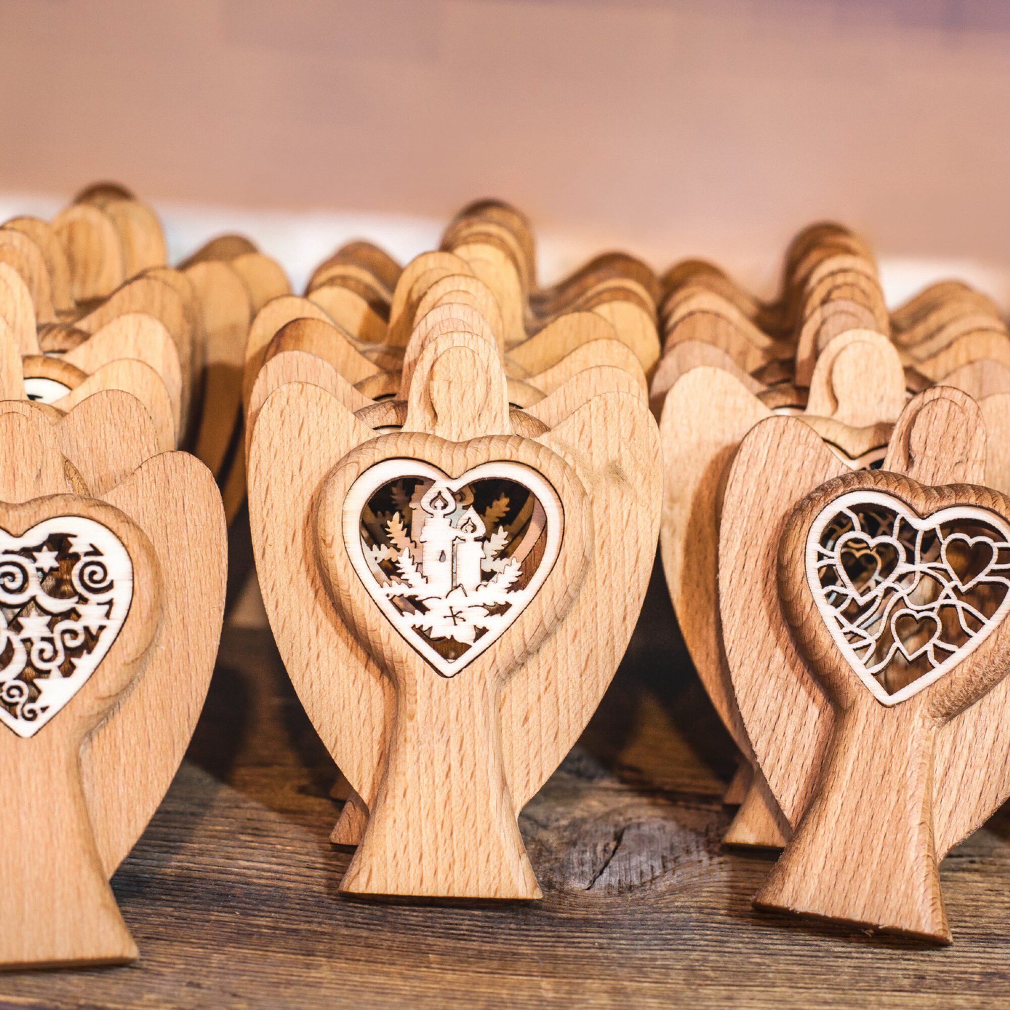 Wooden angel figurines with intricate heart designs.