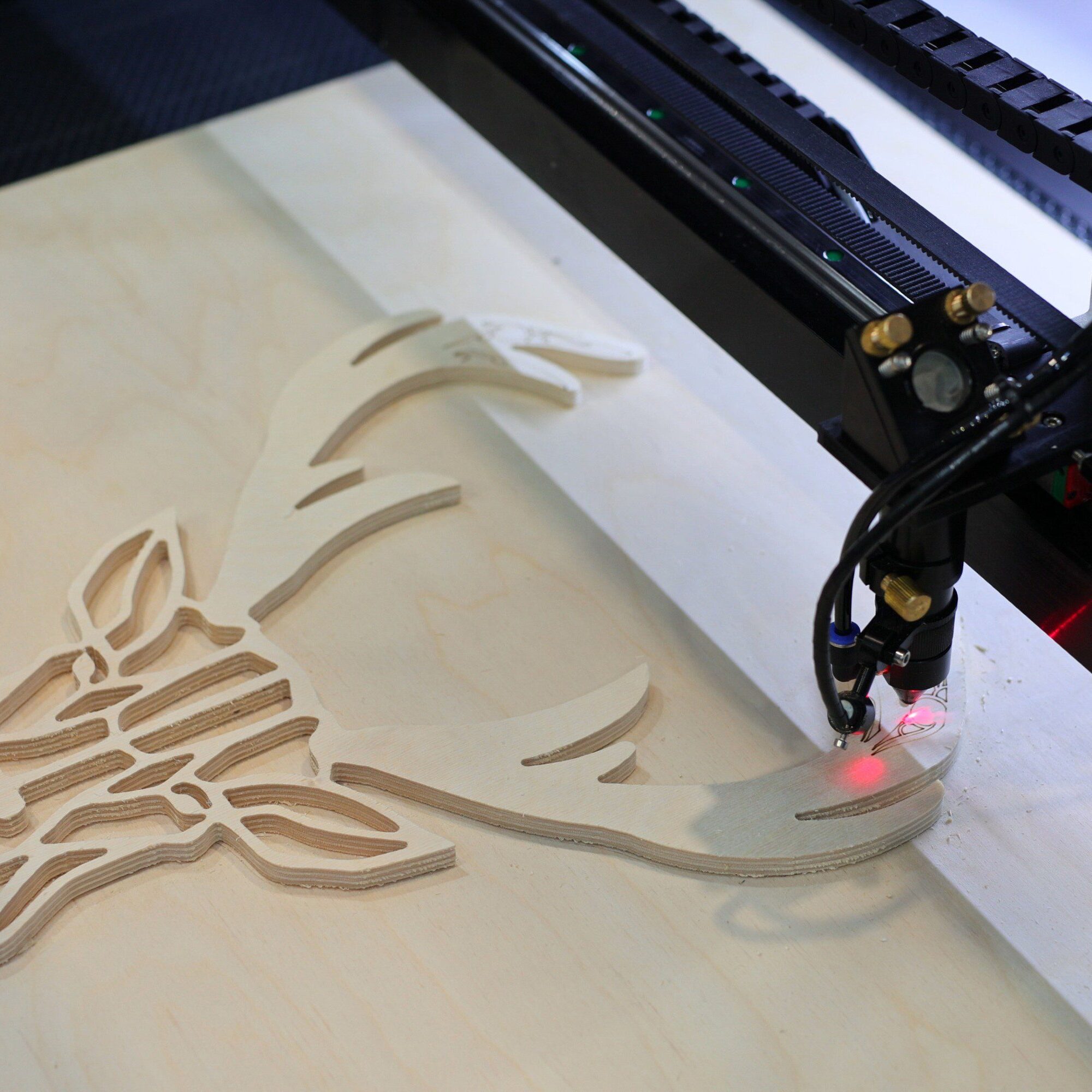 Laser cutting machine carving deer design.