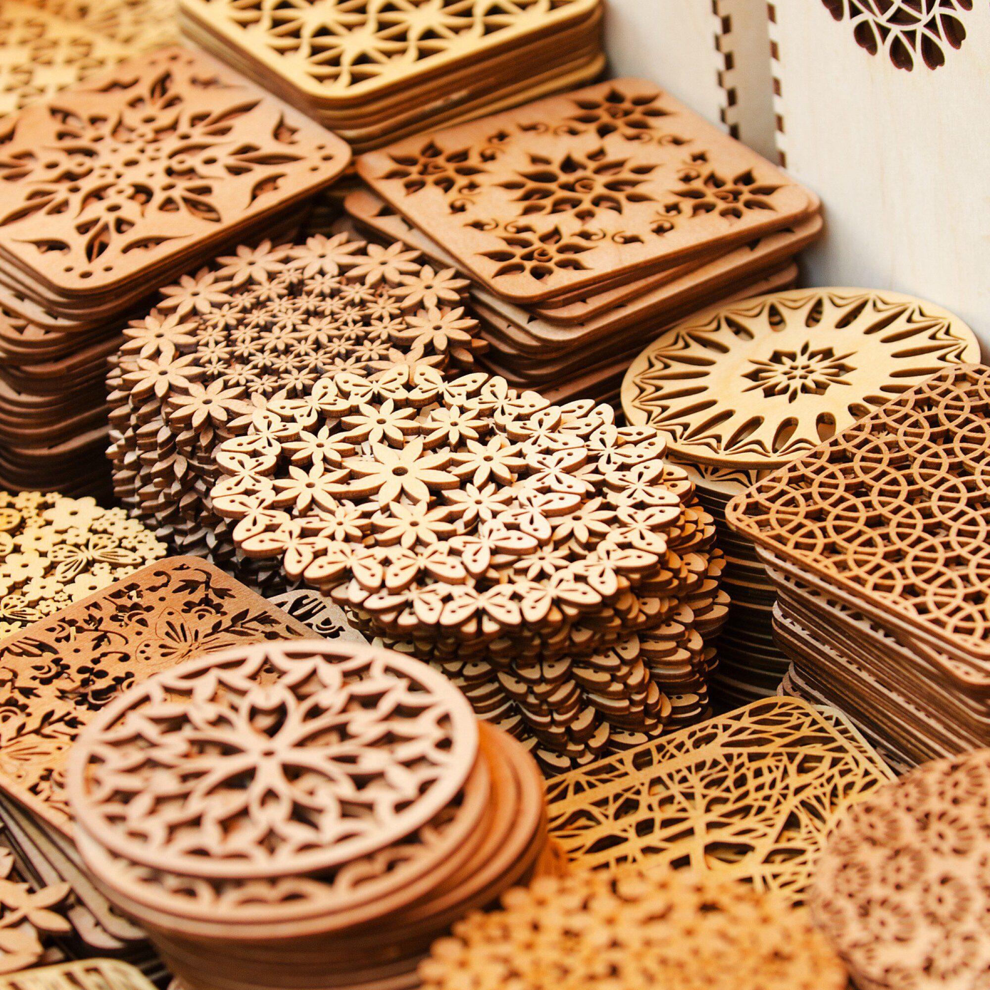 Intricate wooden coasters with ornate designs.